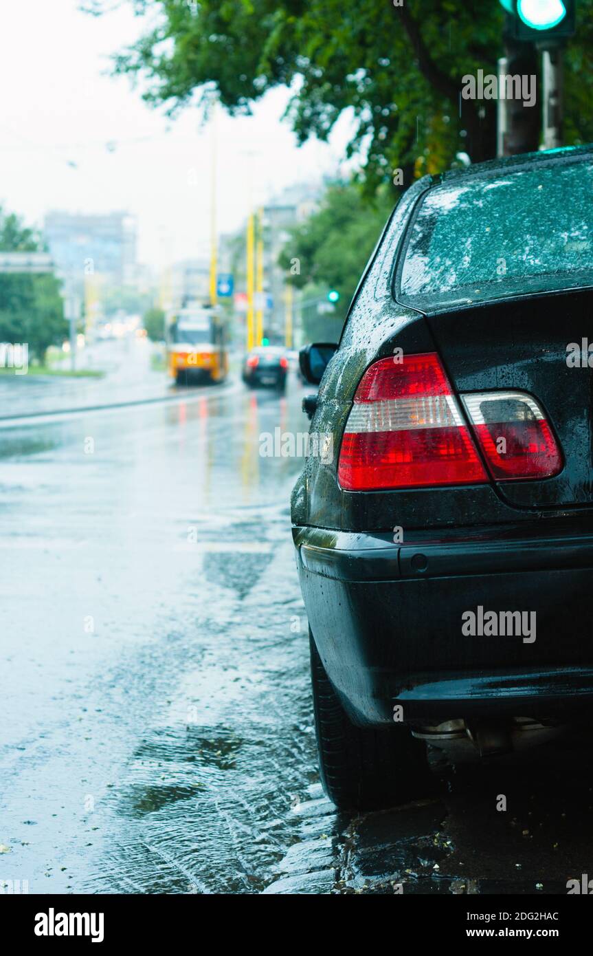 Gros plan d'une voiture de stationnement sous la pluie avec arrière-plan flou Banque D'Images