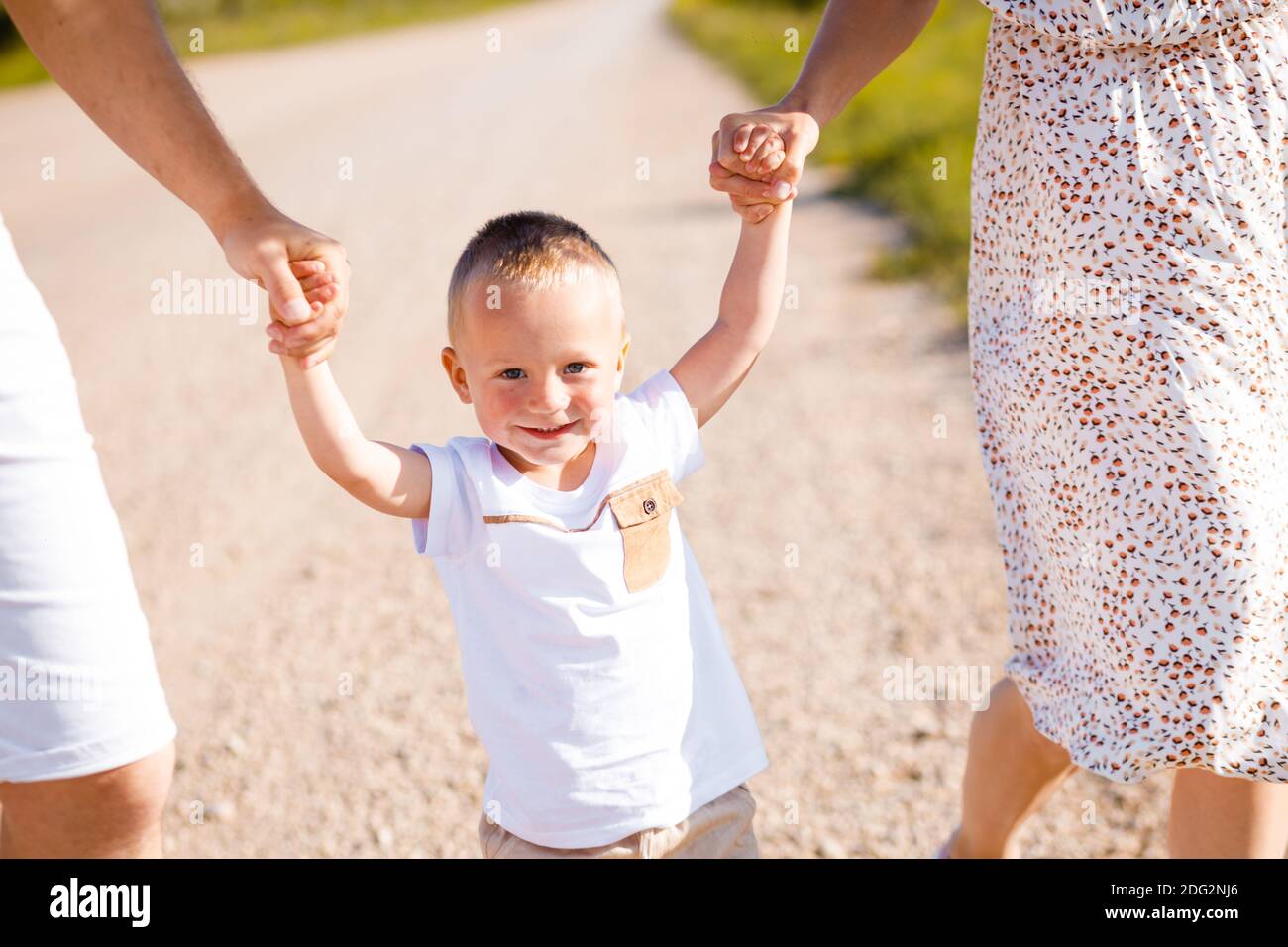 Bonne enfance d'un enfant avec maman et papa. L'enfant tient la main des parents. Banque D'Images