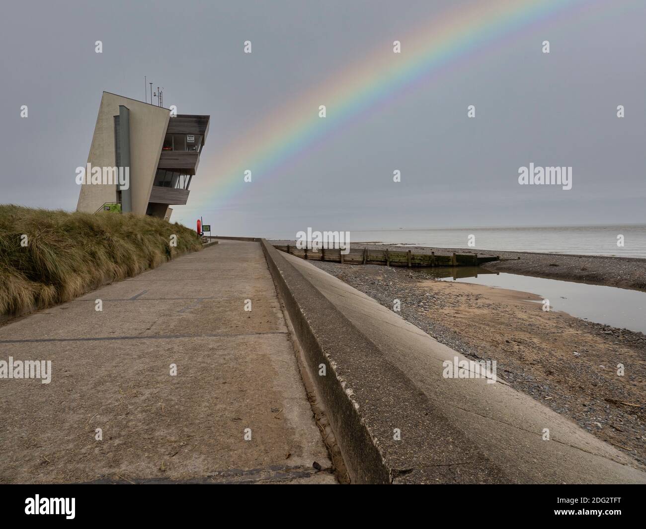 Rainbow à Rossall Beach, Fleetwood, Lancashire, Royaume-Uni. Le bâtiment de quatre étages situé sur la promenade extérieure de Rossall point est la tour Rossall Coastwatch. Banque D'Images