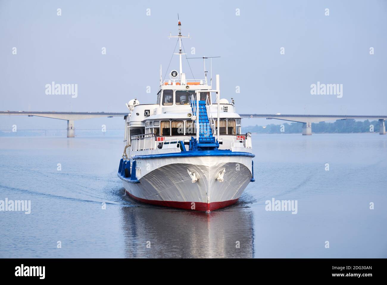 petit bateau à moteur de passagers sur la rivière, vue de face, et un pont routier dans la matinée se hante dans l'arrière-plan Banque D'Images