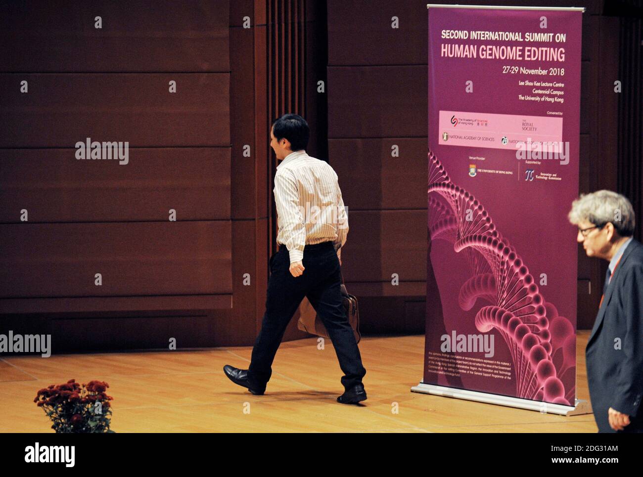 Le biologiste chinois He Jiankui fait une présentation à l'Université de Hong Kong lors du deuxième Sommet international sur l'édition du génome humain. Il avait modifié biologiquement le génome de deux jumeaux pour tenter de les rendre résistants au sida, ce que leur père biologique avait. Il a été condamné par la communauté scientifique, et a été placé en détention immédiatement après son discours et a finalement été emprisonné. À droite se trouve Robin Lovell-badge du Crick Institute. Banque D'Images