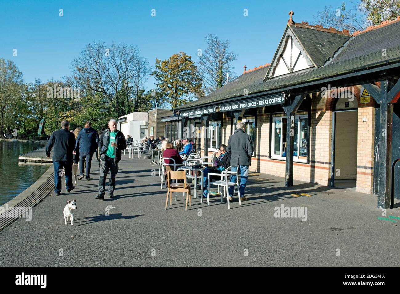 Lakeside café, Alexandra Palace Park avec des gens à des tables à l'extérieur et un petit chien blanc à l'avant, London Borough of Haringey Banque D'Images