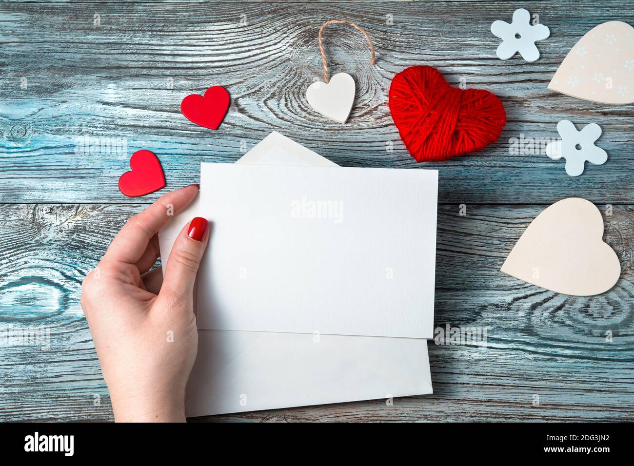 Une femme dans sa main tient une lettre vide sur un fond romantique. Banque D'Images