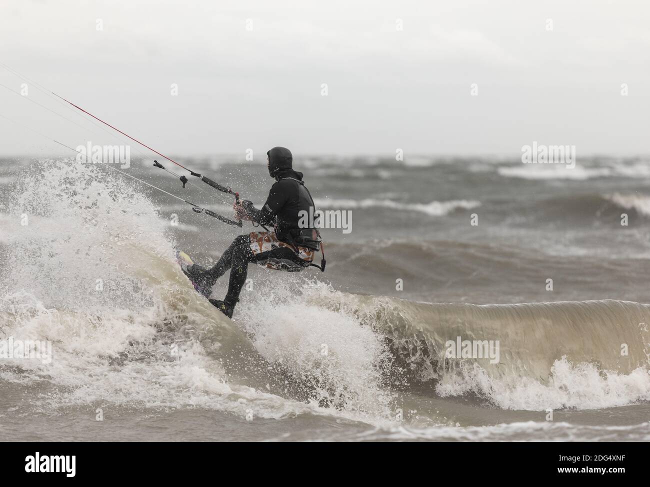Un kiteboarder à cheval sur les vagues de la mer par un jour pluvieux. Boundary Bay, C.-B., Canada-novembre 17,2020. Mise au point sélective, photo de sport, photo de voyage. Banque D'Images
