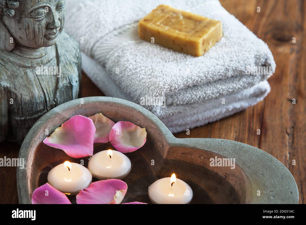 Coeur en pierre avec bougies flottantes et tête de bouddha et serviettes avec du savon Banque D'Images Coeur en pierre avec bougies flottantes et tête de bouddha et serviettes avec du savon Banque D'Images