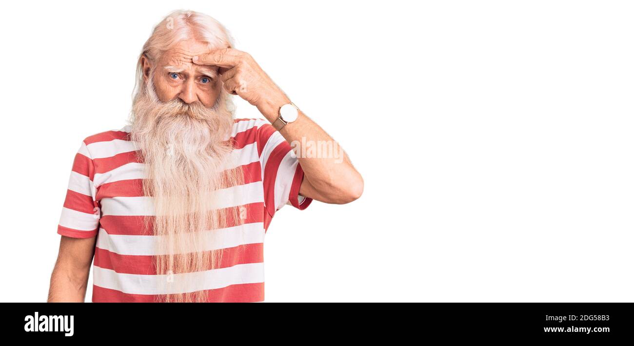 Vieux homme âgé avec cheveux gris et longue barbe portant le tee-shirt rayé pointant malheureux à pipple sur le front, infection laid de la tête noire. Acné et peau Banque D'Images