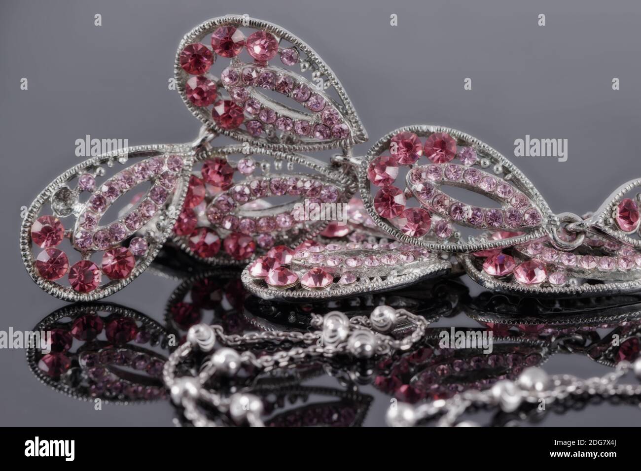 Bijoux en argent sur le fond d'un bijou avec rose pierres Banque D'Images