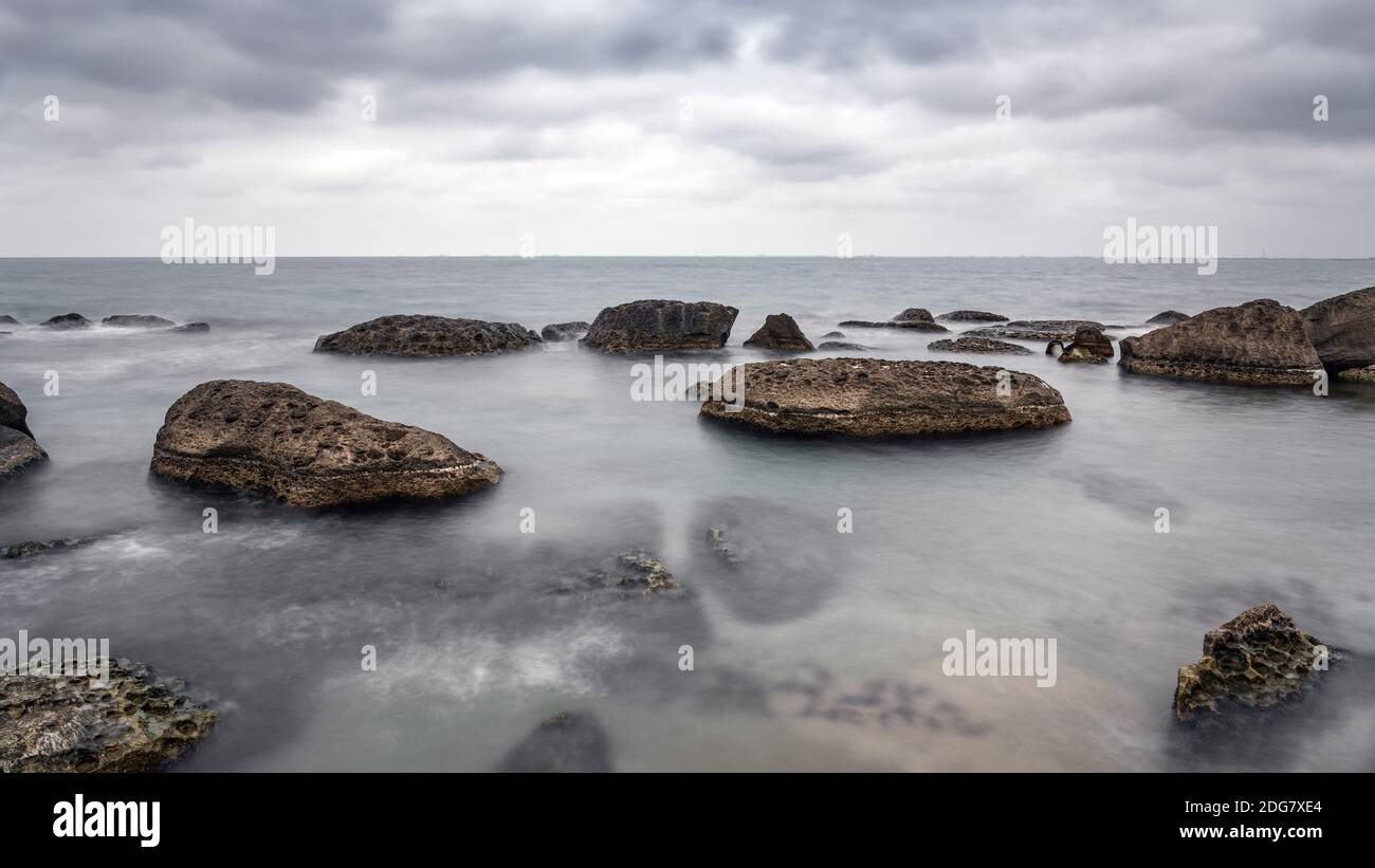 Côte de mer des Rocheuses par temps nuageux, longue exposition eau floue Banque D'Images