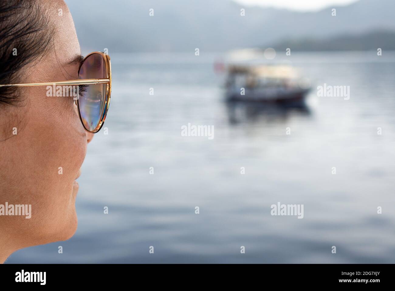 Le visage d'une femme d'âge moyen regarde la mer, assise sur la plage, la femme se reposant en voyage regarde la mer. Concept de vacances à la mer Banque D'Images