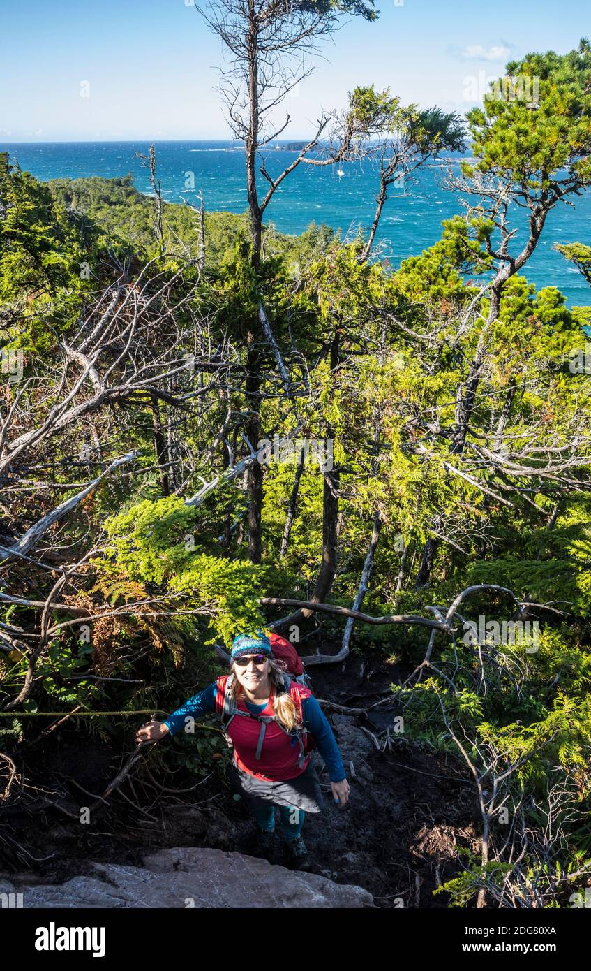 Une femme au sommet de Cox Bay Butte à l'extrémité sud de Cox Bay Beach à Tofino, C.-B., Canada. Banque D'Images