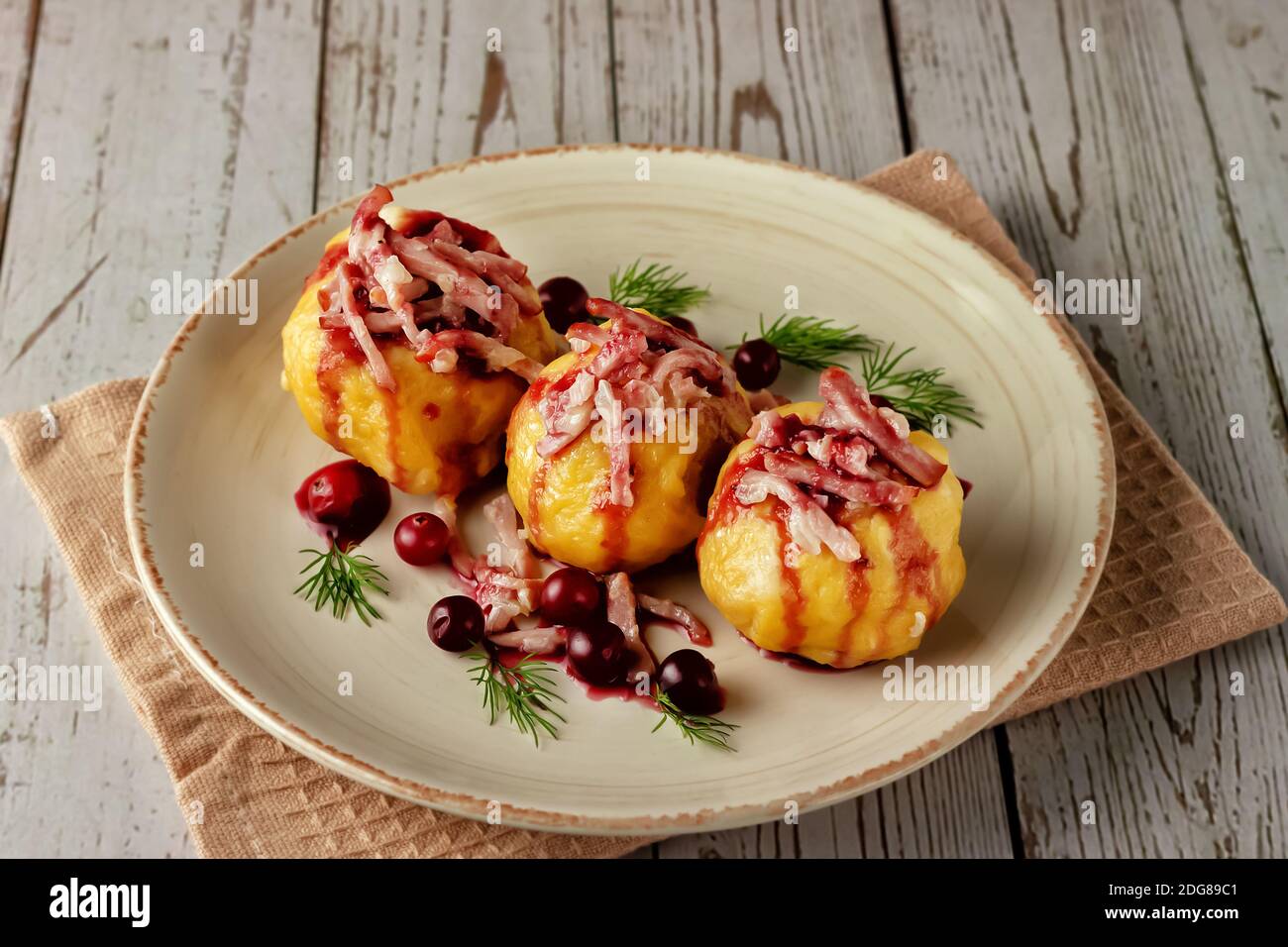 Boulettes de pommes de terre suédoises fraîchement cuites avec sauce aux canneberges sur fond clair. Banque D'Images