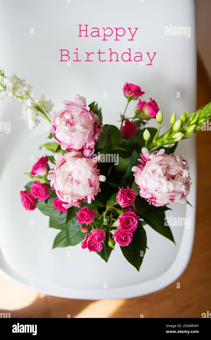 Un beau bouquet de pivoines roses tendres et de petites roses se dresse sur  une chaise blanche. Bouquet de mariage, anniversaire. Joyeux anniversaire  Photo Stock - Alamy