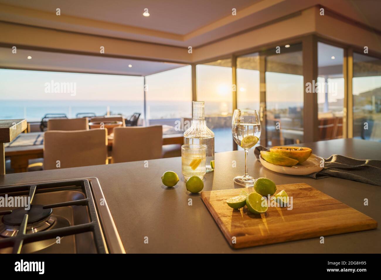 De l'eau et des tranches de citron vert frais sur un comptoir de cuisine de luxe avec vue sur l'océan Banque D'Images