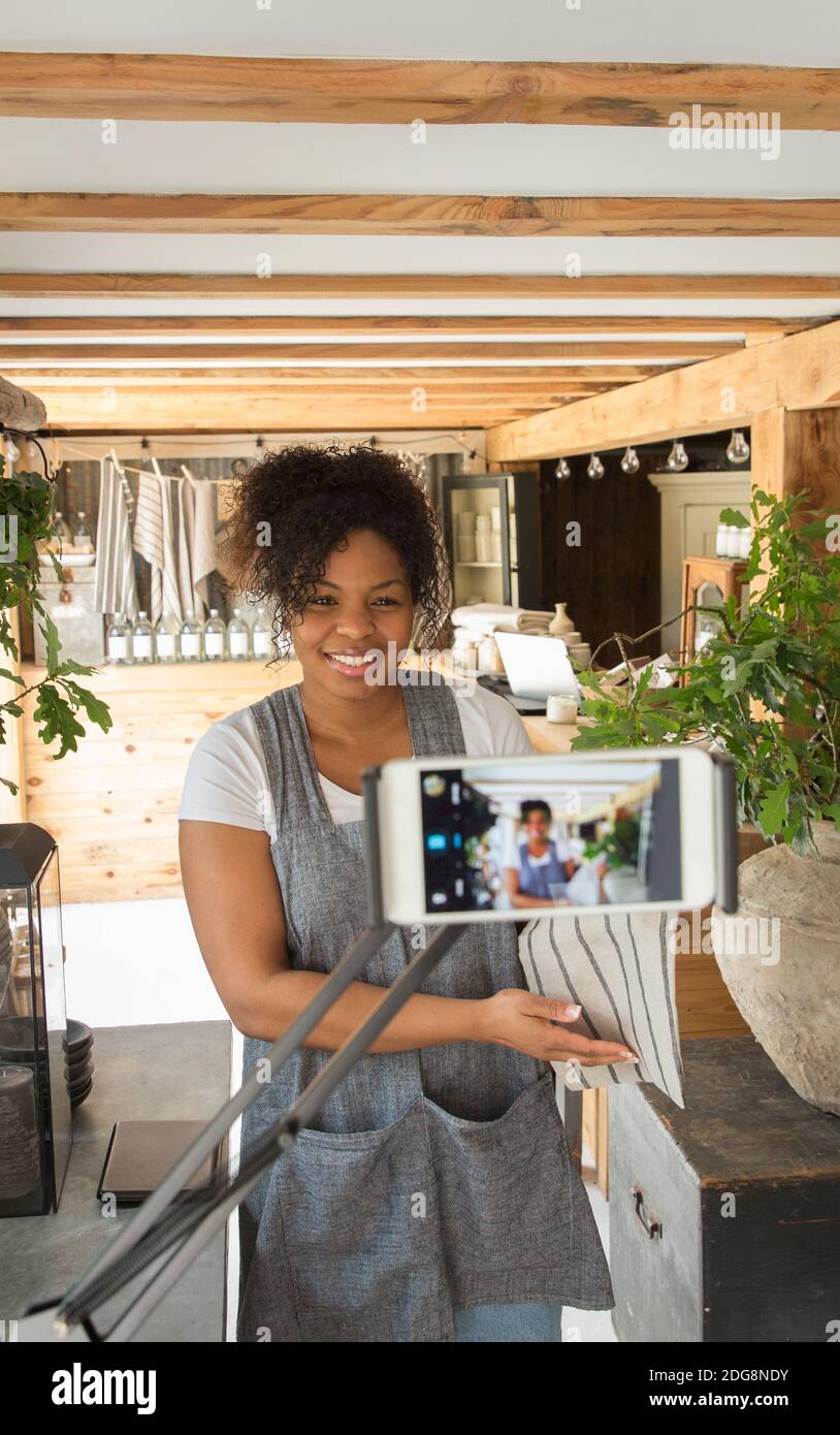 Femme propriétaire de boutique filmant vlog avec caméra téléphone dans l'usine pépinière Banque D'Images