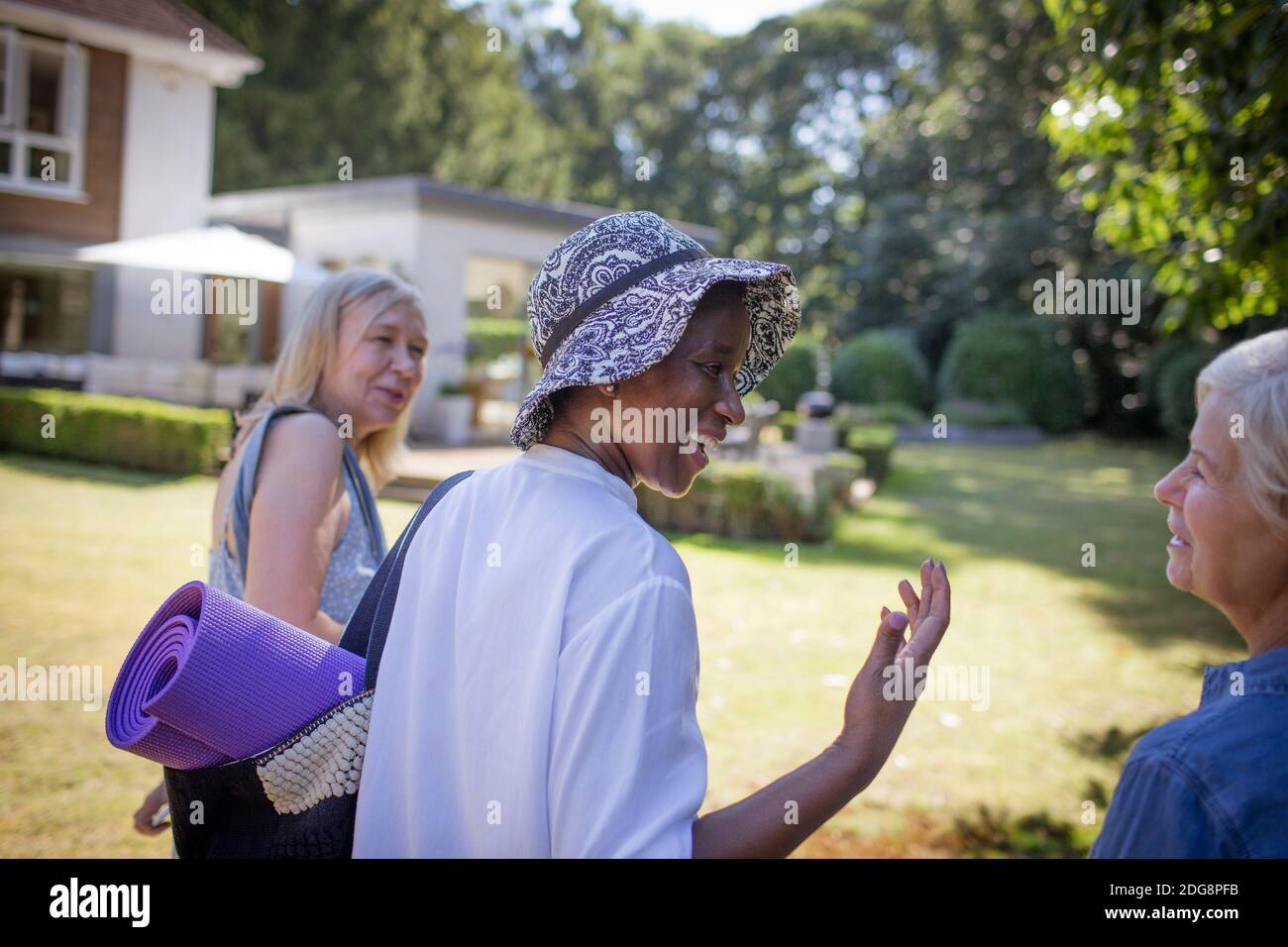 Des femmes âgées heureuses avec tapis de yoga en été ensoleillé jardin Banque D'Images