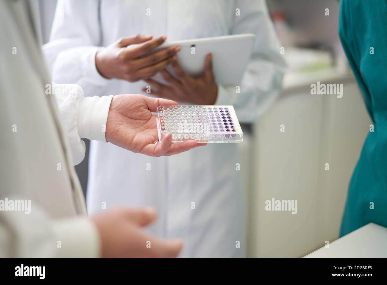 Scientifiques avec tablette numérique et plateau d'échantillons en laboratoire Banque D'Images