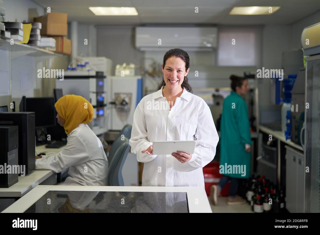 Portrait bonne scientifique féminine avec tablette numérique en laboratoire Banque D'Images