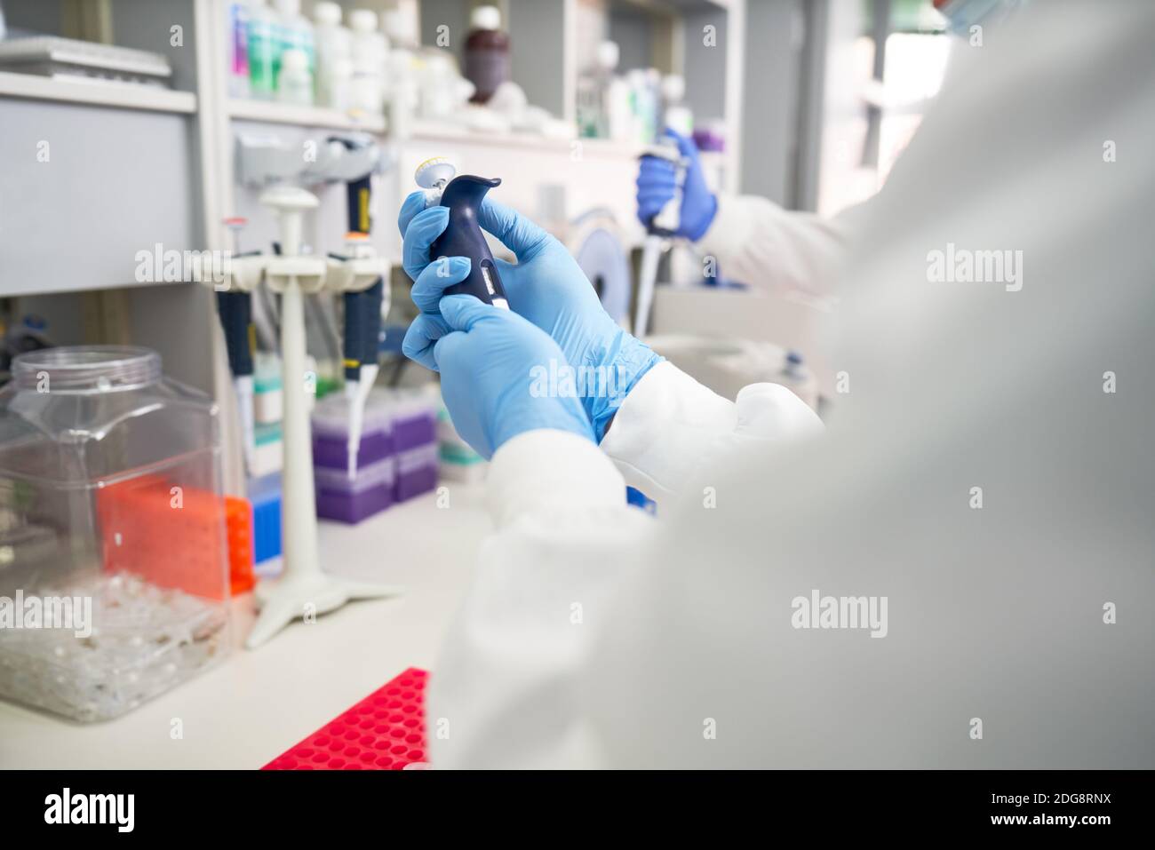Scientifique en gants de caoutchouc préparant une pipette en laboratoire Banque D'Images