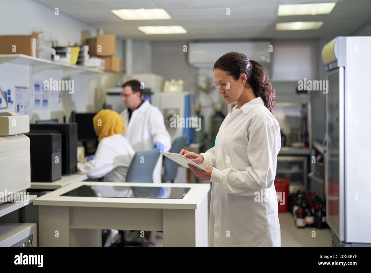 Scientifique féminin utilisant une tablette numérique en laboratoire Banque D'Images