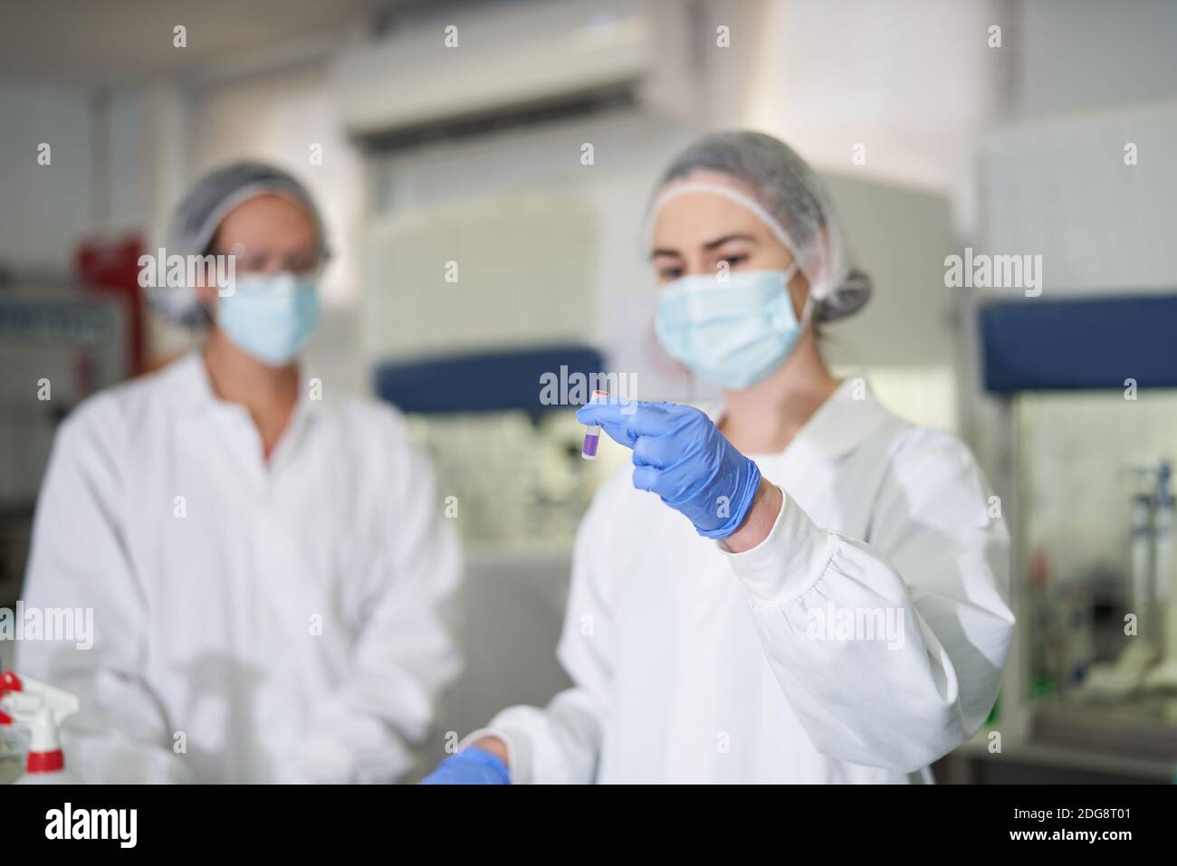 Femmes scientifiques en vêtements de travail de protection examinant l'échantillon Banque D'Images