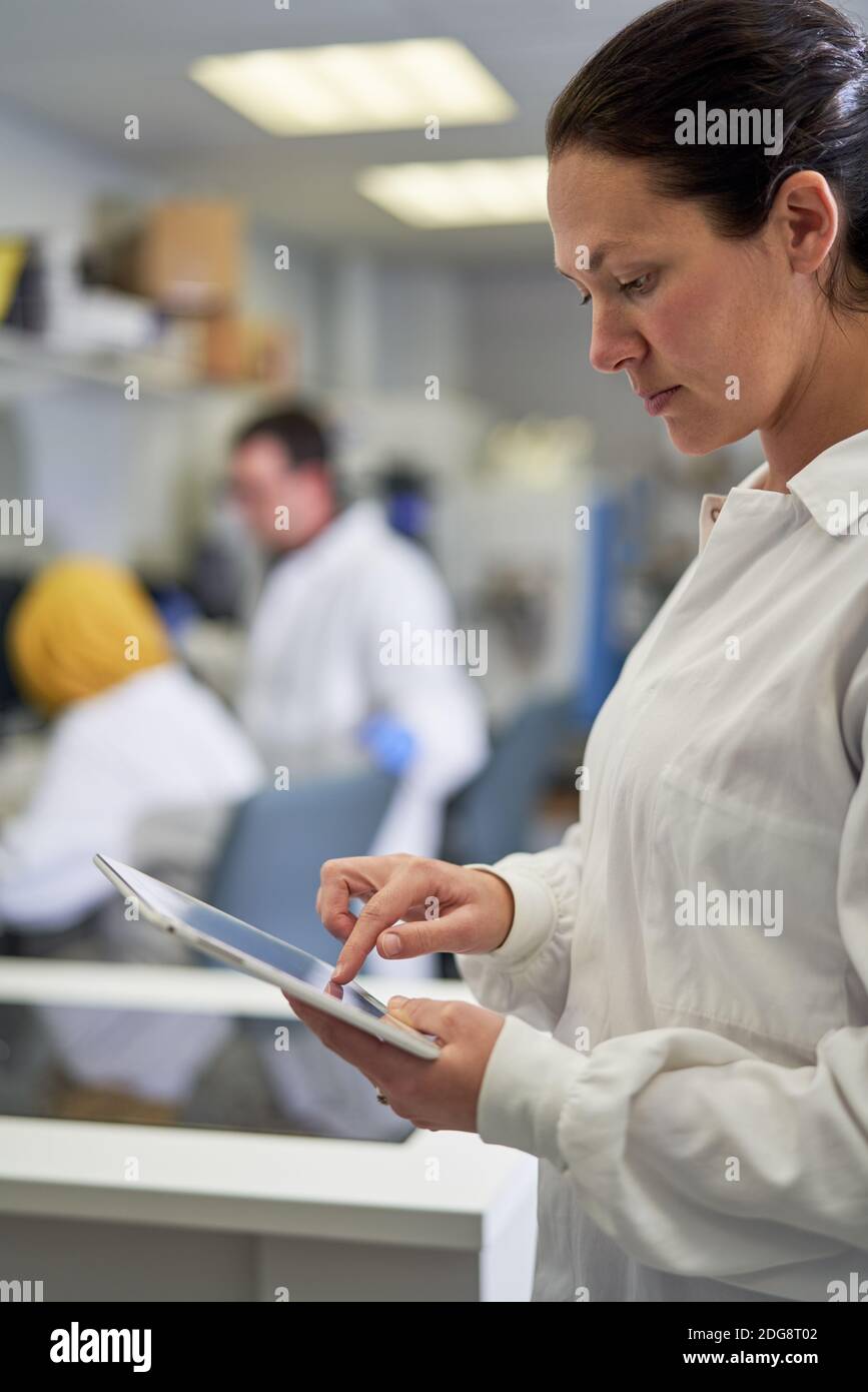 Scientifique féminin utilisant une tablette numérique en laboratoire Banque D'Images