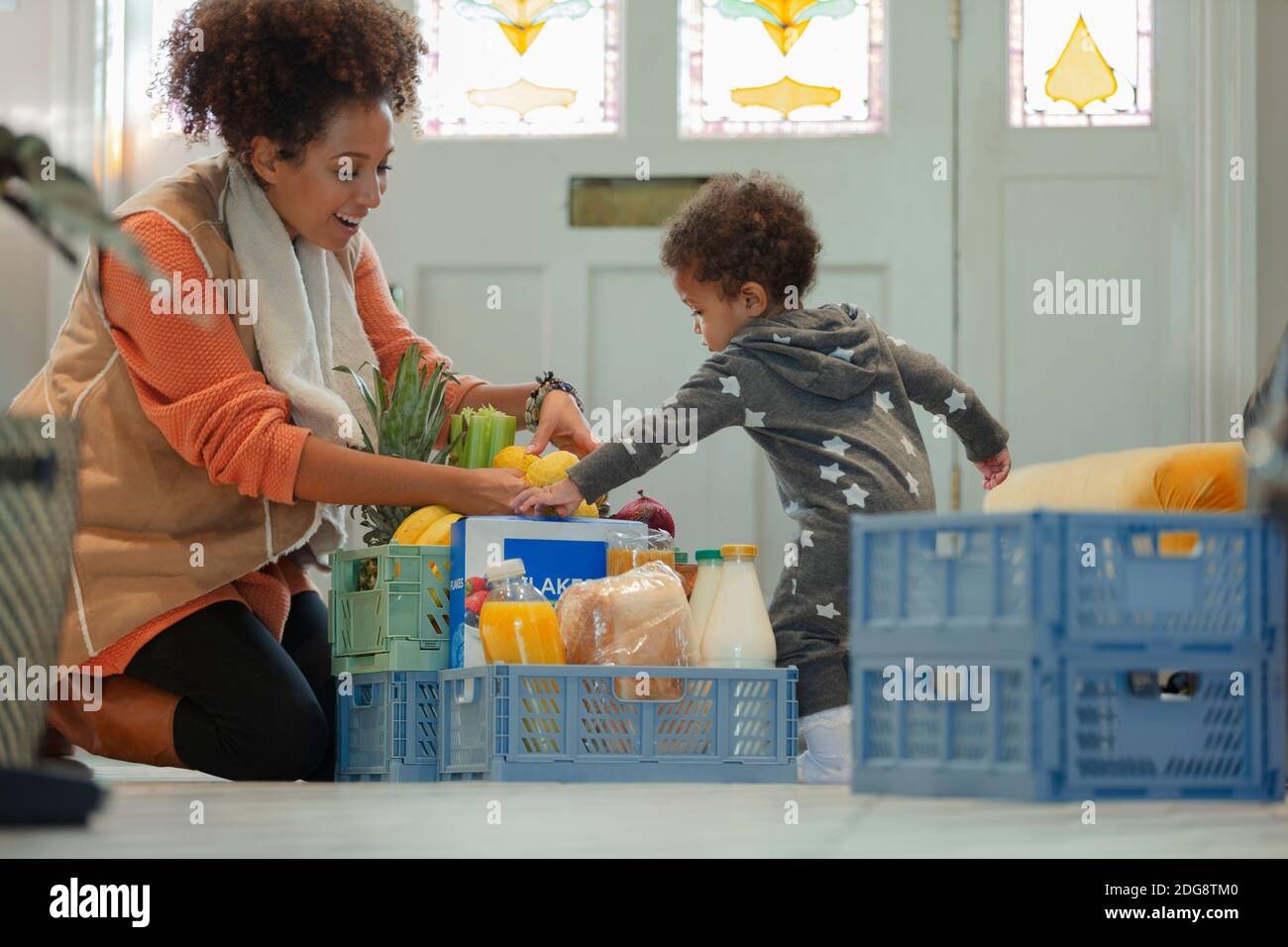 Petite fille aidant la mère à décharger la livraison d'épicerie Banque D'Images