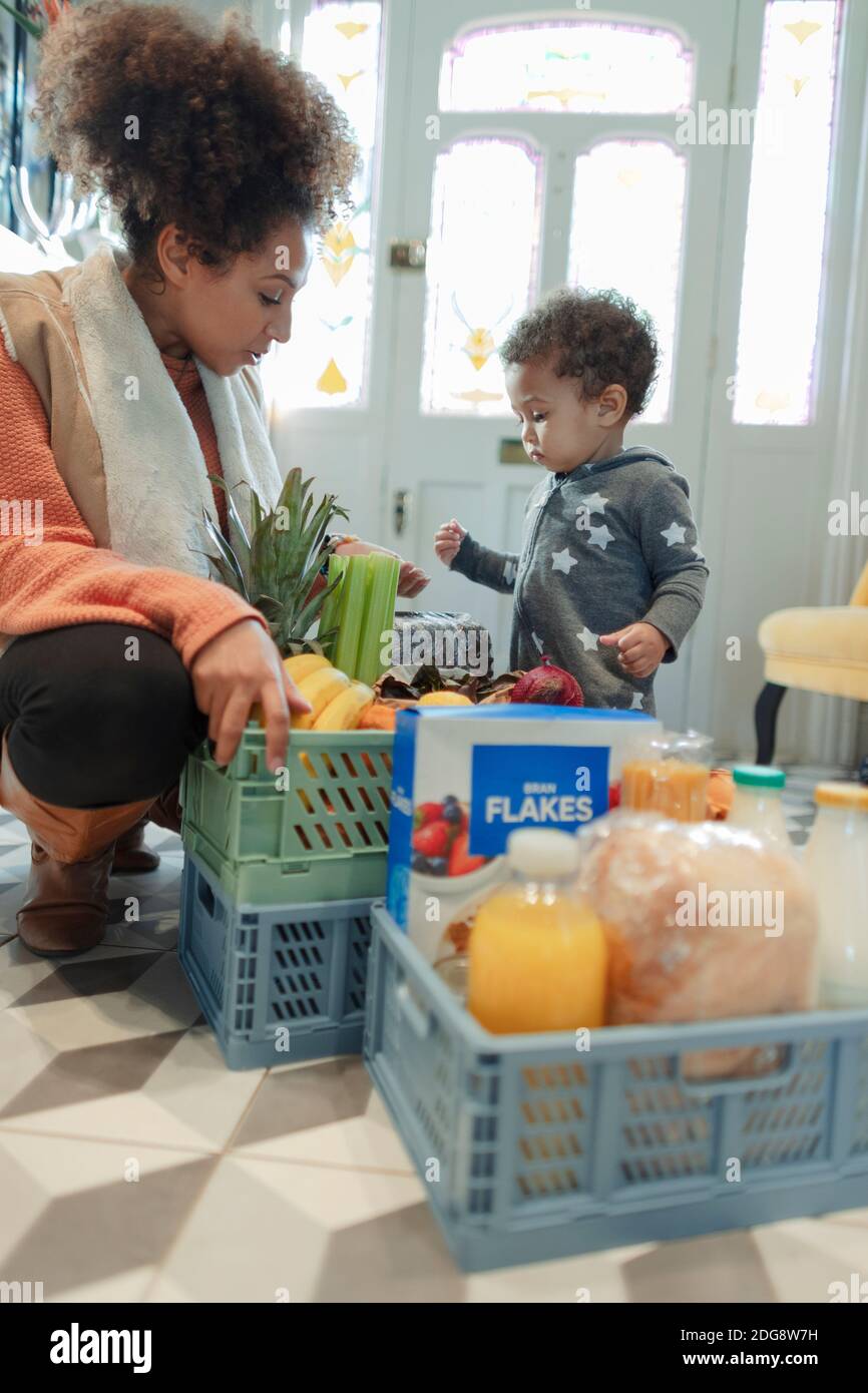 La mère et la petite fille reçoivent une livraison d'épicerie à la maison Banque D'Images