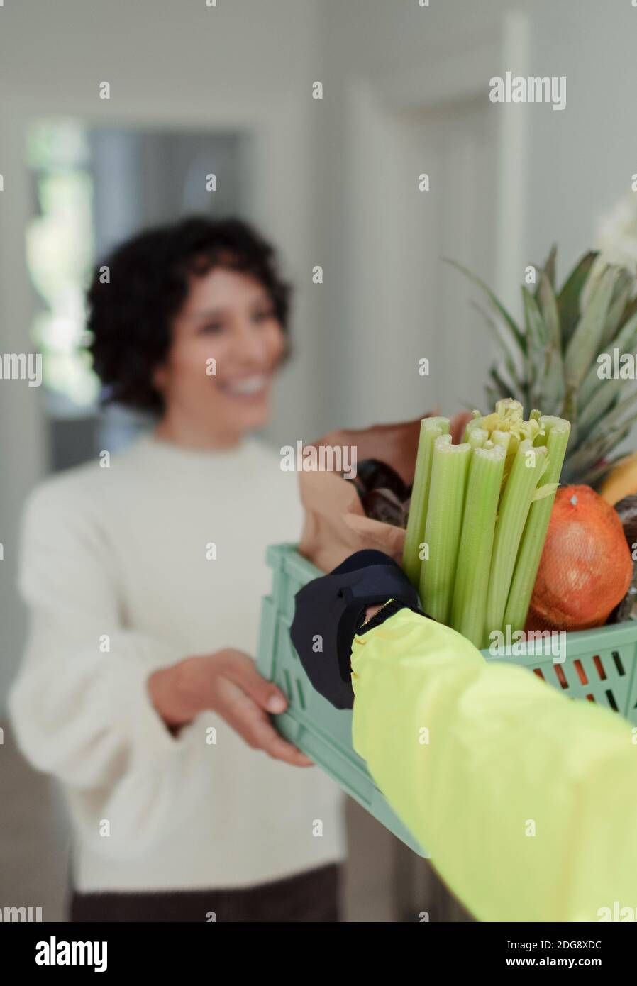 Femme recevant une livraison d'épicerie par un service de messagerie Banque D'Images