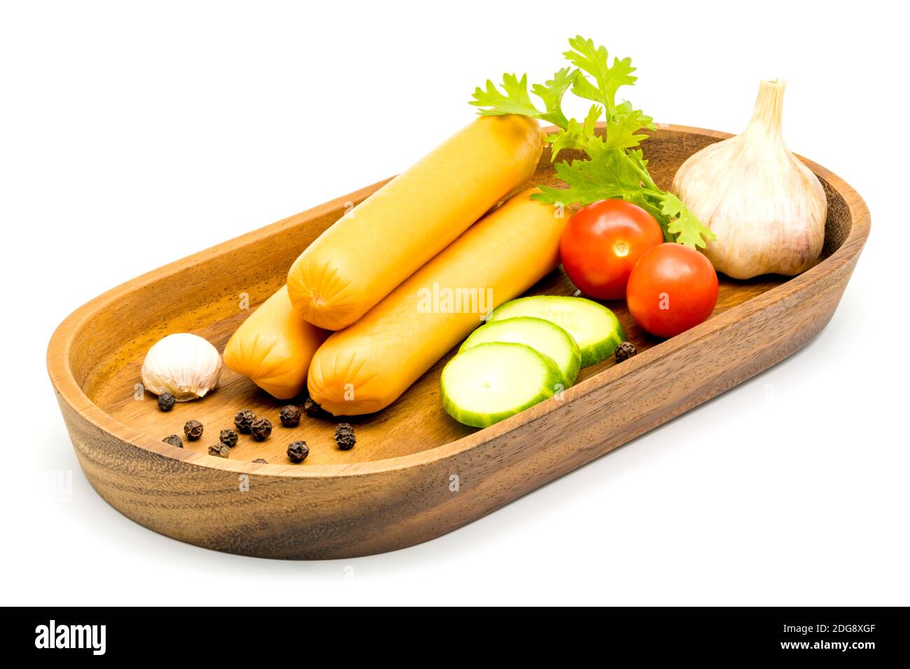 Saucisses, légumes, ail et poivrons noirs dans un plateau en bois Banque D'Images