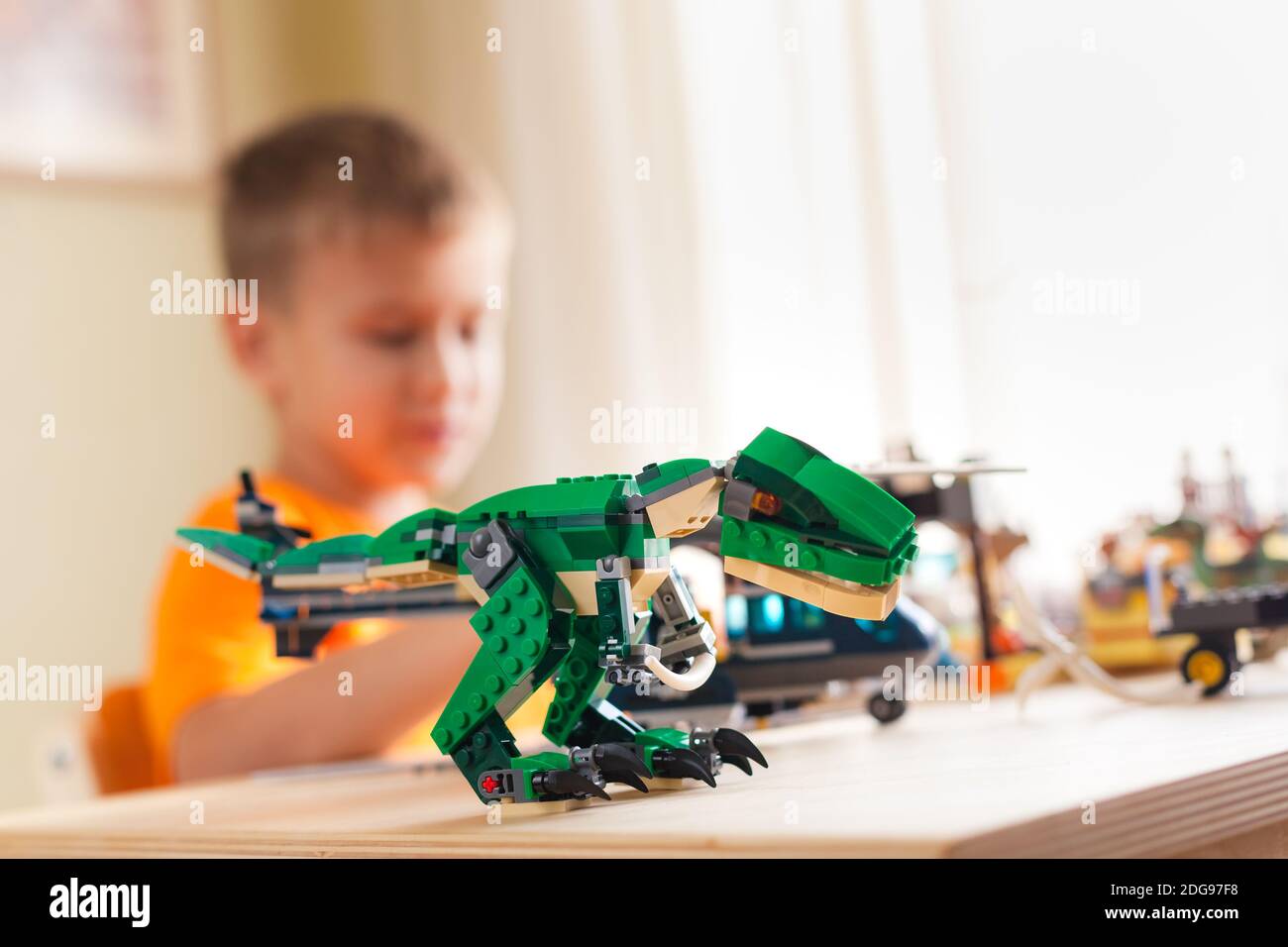 SAINT-PÉTERSBOURG, RUSSIE - 26 NOVEMBRE 2020 Tyrannosaurus assemblé à partir de briques lego et silhouette d'enfant en flou sur fond Banque D'Images