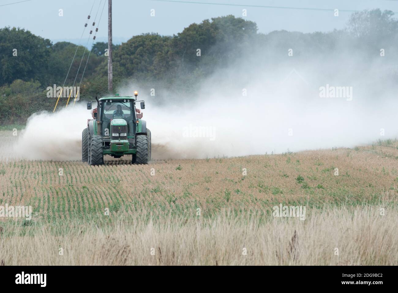 Un tracteur John Deere répand de l'engrais à la chaux sur les terres agricoles de l'île Hayling, au Hampshire, au Royaume-Uni Banque D'Images
