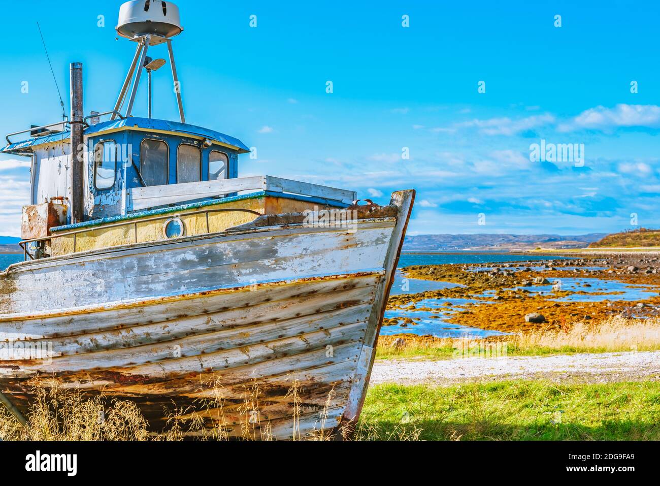 Vieux bateau de pêche abandonné brillant qui est tiré dessus la côte Banque D'Images