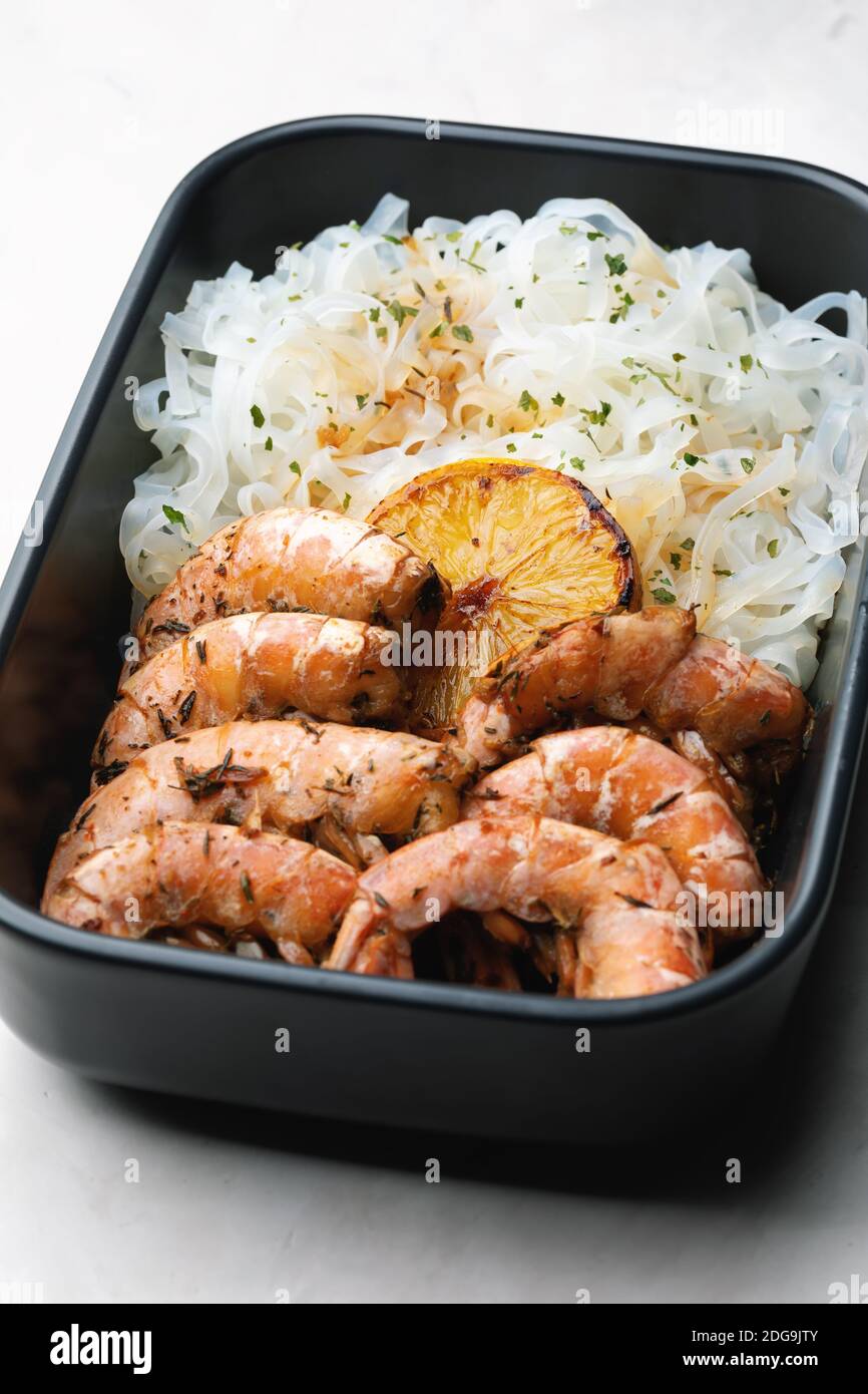 Cuisine asiatique : nouilles de riz aux crevettes et aux herbes dans un bol. Sauce soja à l'ail, au gingembre et au citron. Banque D'Images