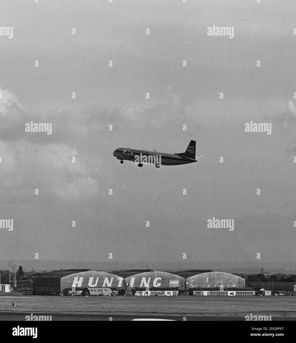 Image monochrome d'archive d'un avion de ligne Vickers Vanguard 953C Merchantman dans British Airways fret livrée dans l'air à l'aéroport de Heathrow, Londres, 1979, avec une vue de Hunting-Clan Air transport hangar, démoli 1986. Peut-être G-APEP 'Superb' maintenant au Brooklands Museum Surrey England. Autre récolte 2JF3A1E Banque D'Images