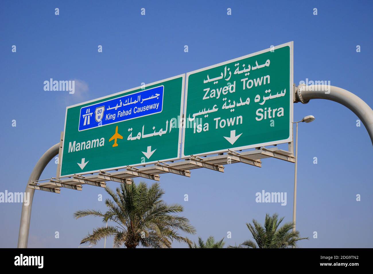 Signalisation routière bilingue, arabe et anglais, indiquant la chaussée du Roi Fahd, Manama, l'aéroport international, Zayed Town, ISA Town, Sitra, Bahreïn Banque D'Images
