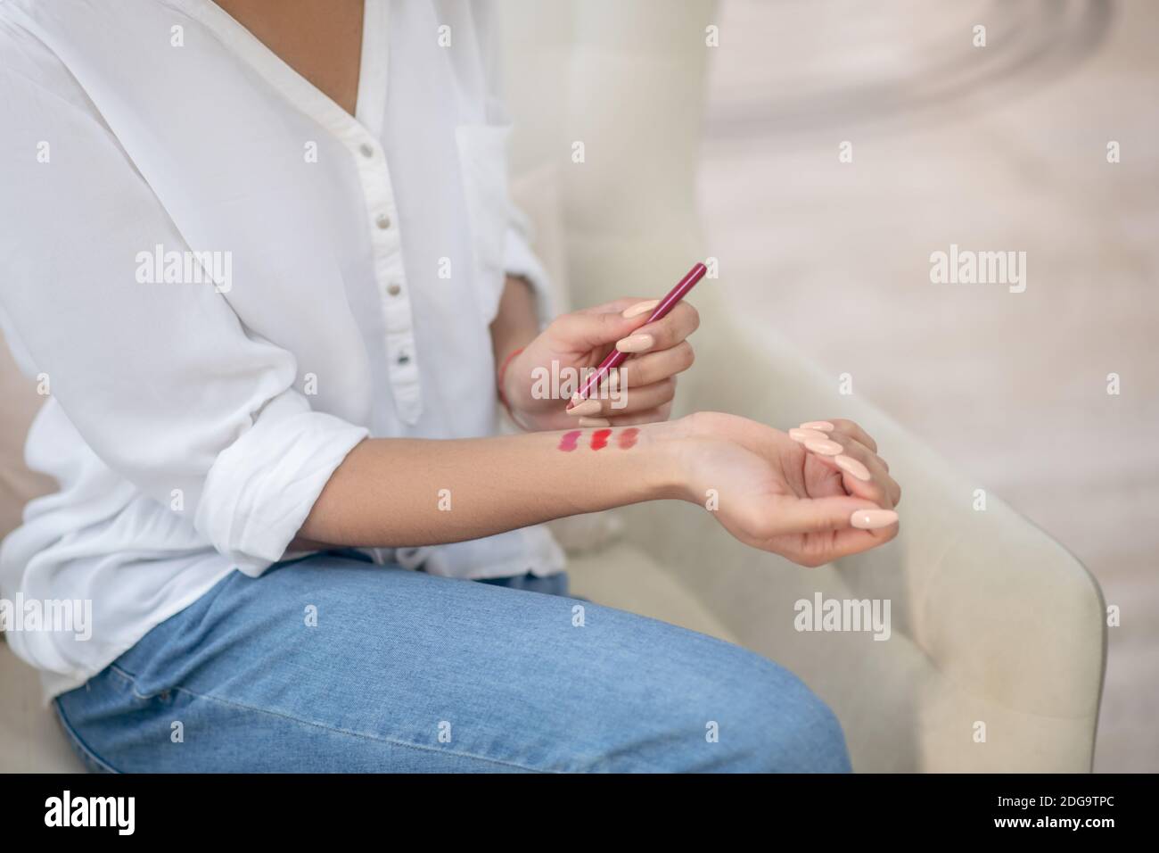 Femme essayant différentes tonalités de crayon rouge à lèvres Banque D'Images