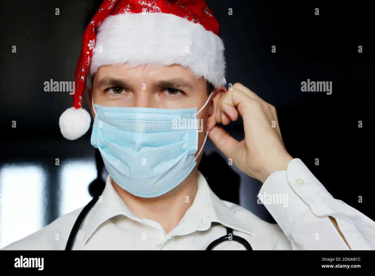 Portrait d'un médecin en masque médical et chapeau du Père Noël. Célébration de Noël en clinique pendant la pandémie du coronavirus Banque D'Images