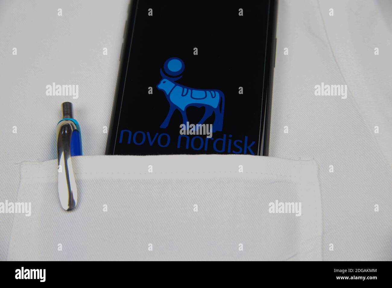 Viersen, Allemagne - avril 9. 2020: Gros plan de l'écran de téléphone mobile avec le logo de la société pharmaceutique Novo Nordisk dans la poche d'un médecin blanc Banque D'Images