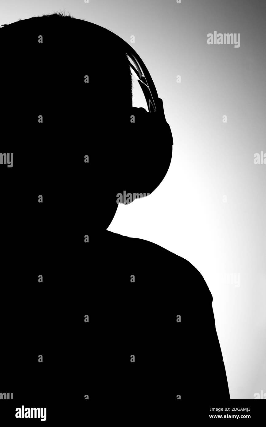 Silhouette de garçon en noir et blanc avec écouteurs musique Banque D'Images