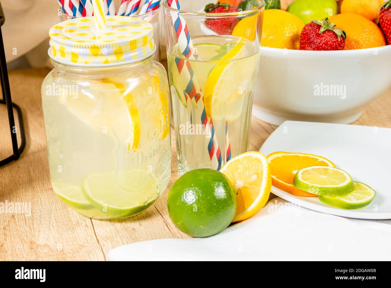 Distributeur de boissons naturelles avec jus d'agrumes faits maison sur une surface en bois, différents types de verres et de cruches avec sorbet et glace avec jus et un Banque D'Images