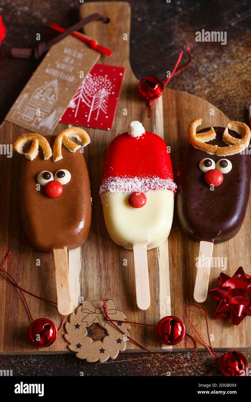 Сhocolate popsicle. Concept de Noël. Glace au chocolat sur un bâton avec un visage de cerf de Noël et un nez rouge bonbon. Cuisson de Noël. Préparations f Banque D'Images