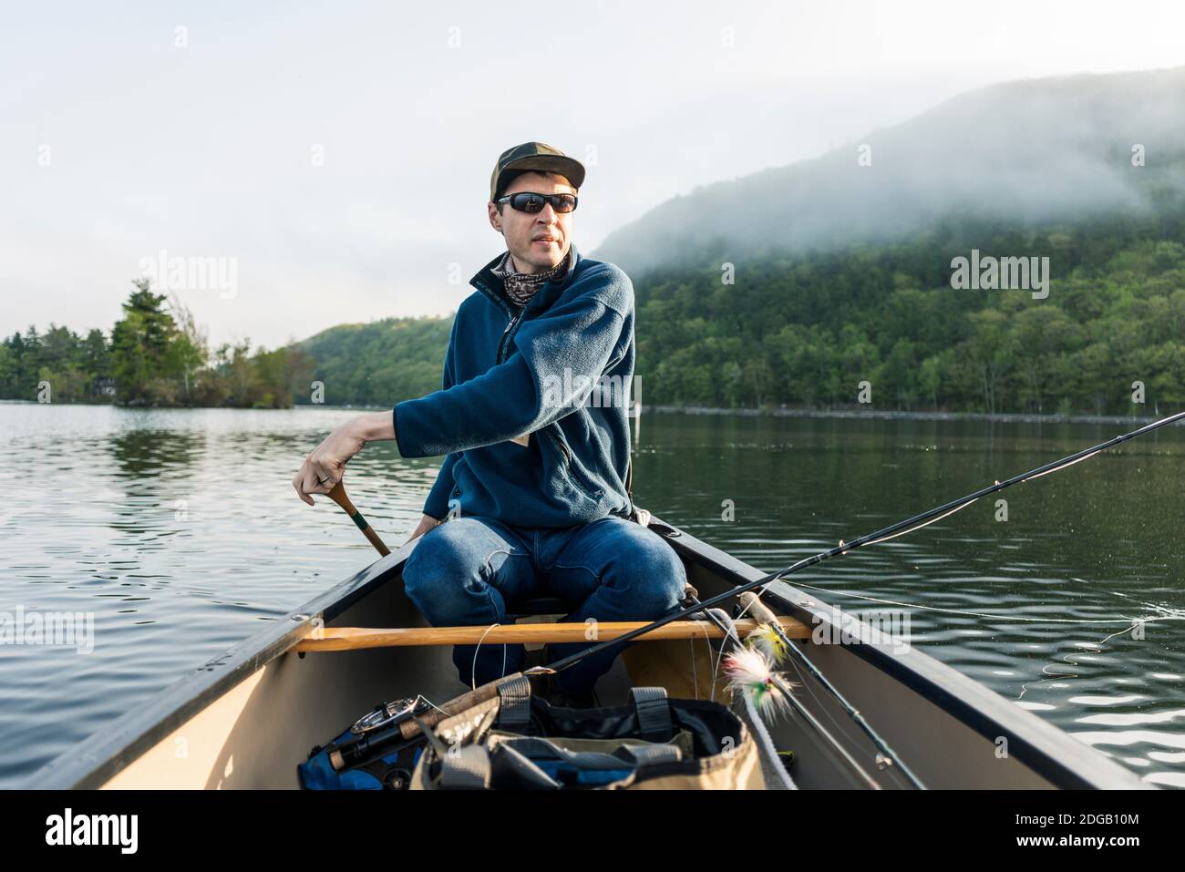 Canoë pêche à la mouche tôt le matin à Camden, Maine sur le lac Megunticook. Banque D'Images