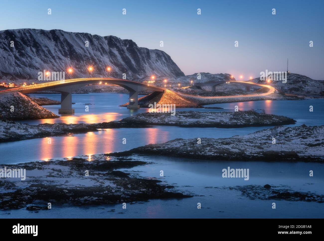 Pont illuminé, montagnes enneigées et ciel bleu Banque D'Images
