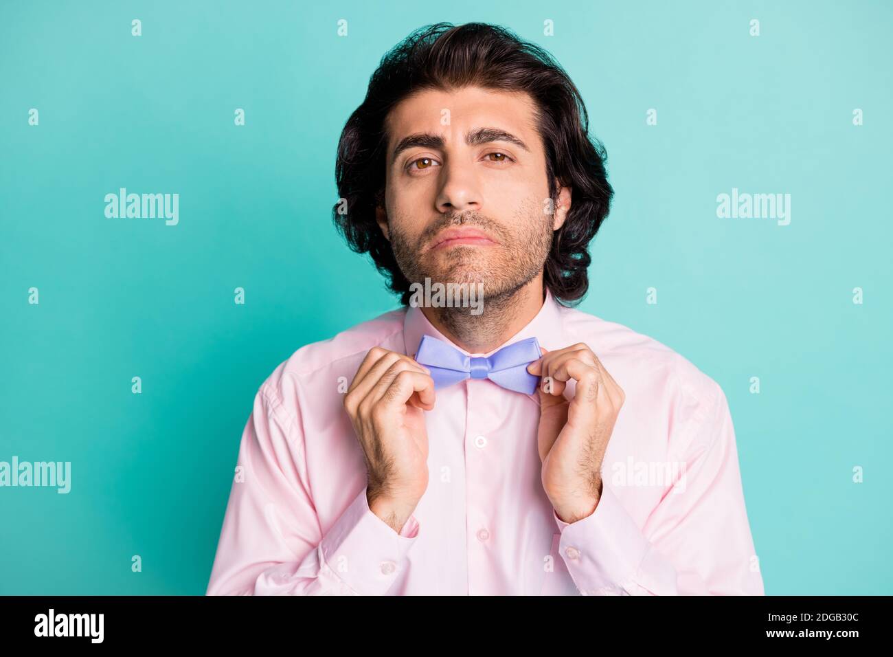 Photo portrait de beau doux homme habillé rose tenue préparation date de  fixation noeud papillon isolé teal couleur fond Photo Stock - Alamy