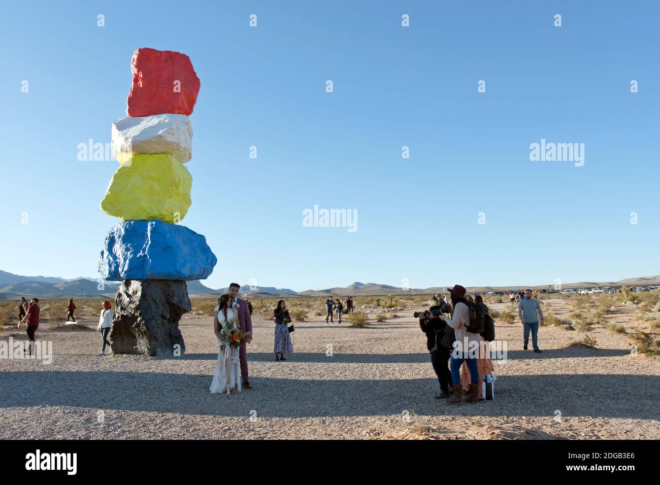 Une mariée et un marié font des photos dans sept montagnes magiques, une œuvre d'art de rochers empilés et peints de couleurs vives, dans le désert près de Las Vegas. Banque D'Images