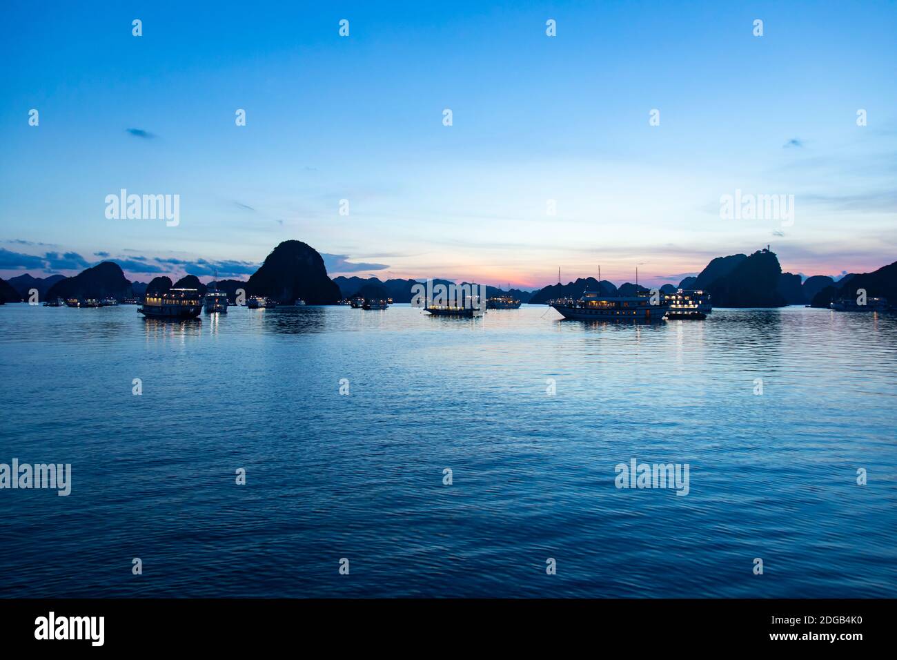 Après le coucher du soleil sur la baie d'Ha long, site classé au patrimoine mondial de l'UNESCO. Chaque jour, des voiles paquebots naviguent dans le complexe rocheux rempli de touristes Banque D'Images