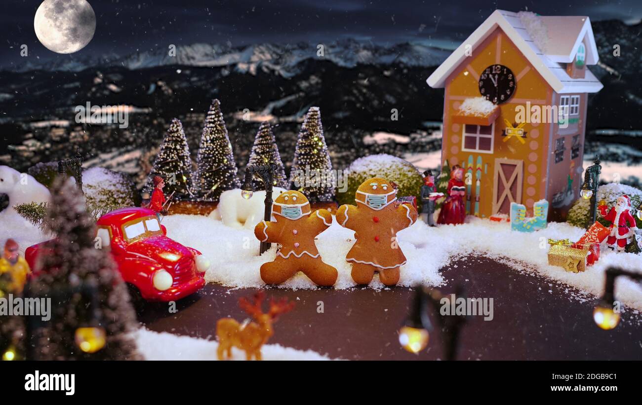 Biscuits de pain d'épice dans le village magique de Noël avec masque médical de protection. Sécurité Noël vacances d'hiver pendant le concept de pandémie de coronavirus. Banque D'Images