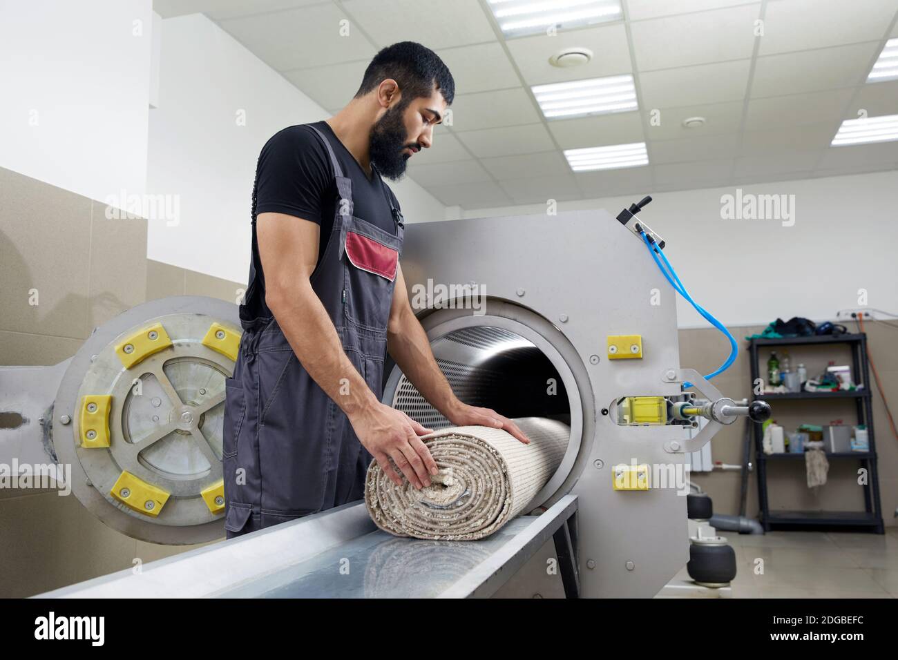 Homme utilisant la machine de séchage pour le nettoyage de tapis. Service professionnel de nettoyage de tapis Banque D'Images