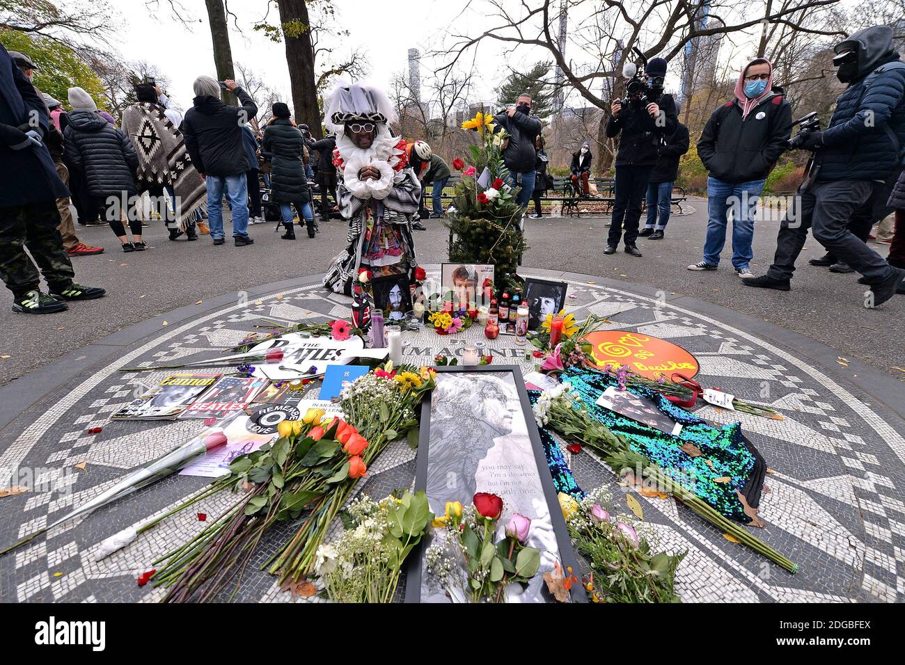 New York, États-Unis. 08 décembre 2020. Les gens placent des fleurs et des images sur la mosaïque imagine à Strawberry Fields, à Central Park, pour commémorer le 40e anniversaire de la mort du musicien John Lennon, New York, NY, le 8 décembre 2020. L'ancien Beatle a été abattu par un fan devant sa résidence, le Dakota, dans la soirée du 8 décembre 1980, dans l'Upper West Side de Manhattan. (Photo par Anthony Behar/Sipa USA) crédit: SIPA USA/Alay Live News Banque D'Images