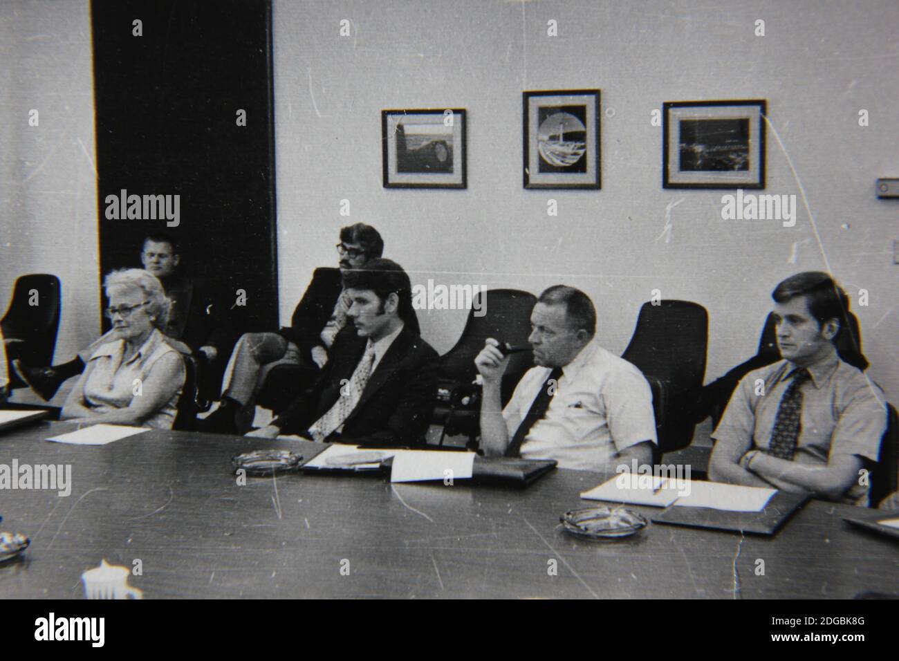 Belle photographie en noir et blanc vintage des années 1970 d'une réunion d'affaires remplie de professionnels de cols blancs dans une immense salle de conférence. Banque D'Images